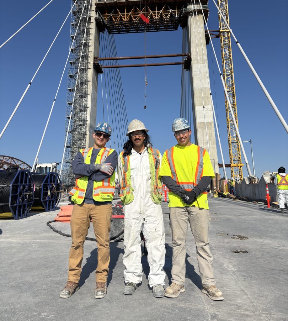 Three cement masons posing for a picture on the new Pattullo Bridge in construction.