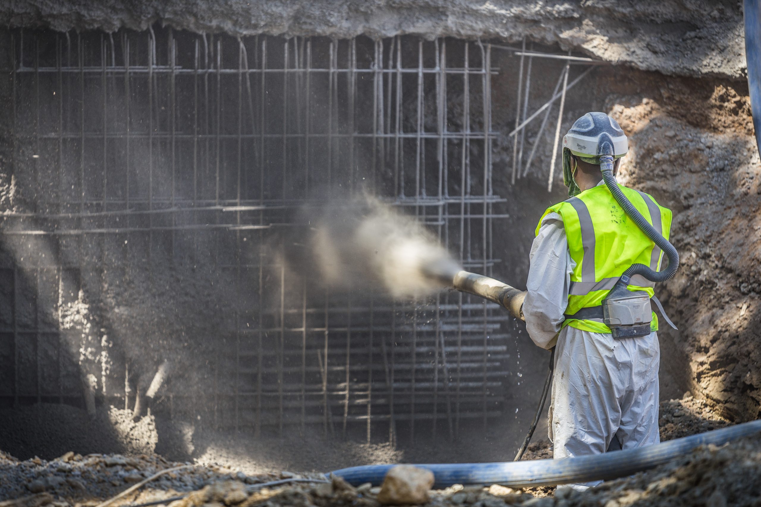 An image of a man spraying concrete for building construction