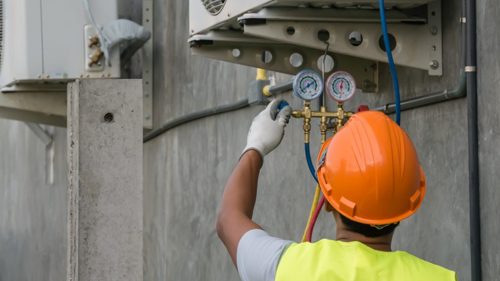 An image of a technician checking an air conditioner