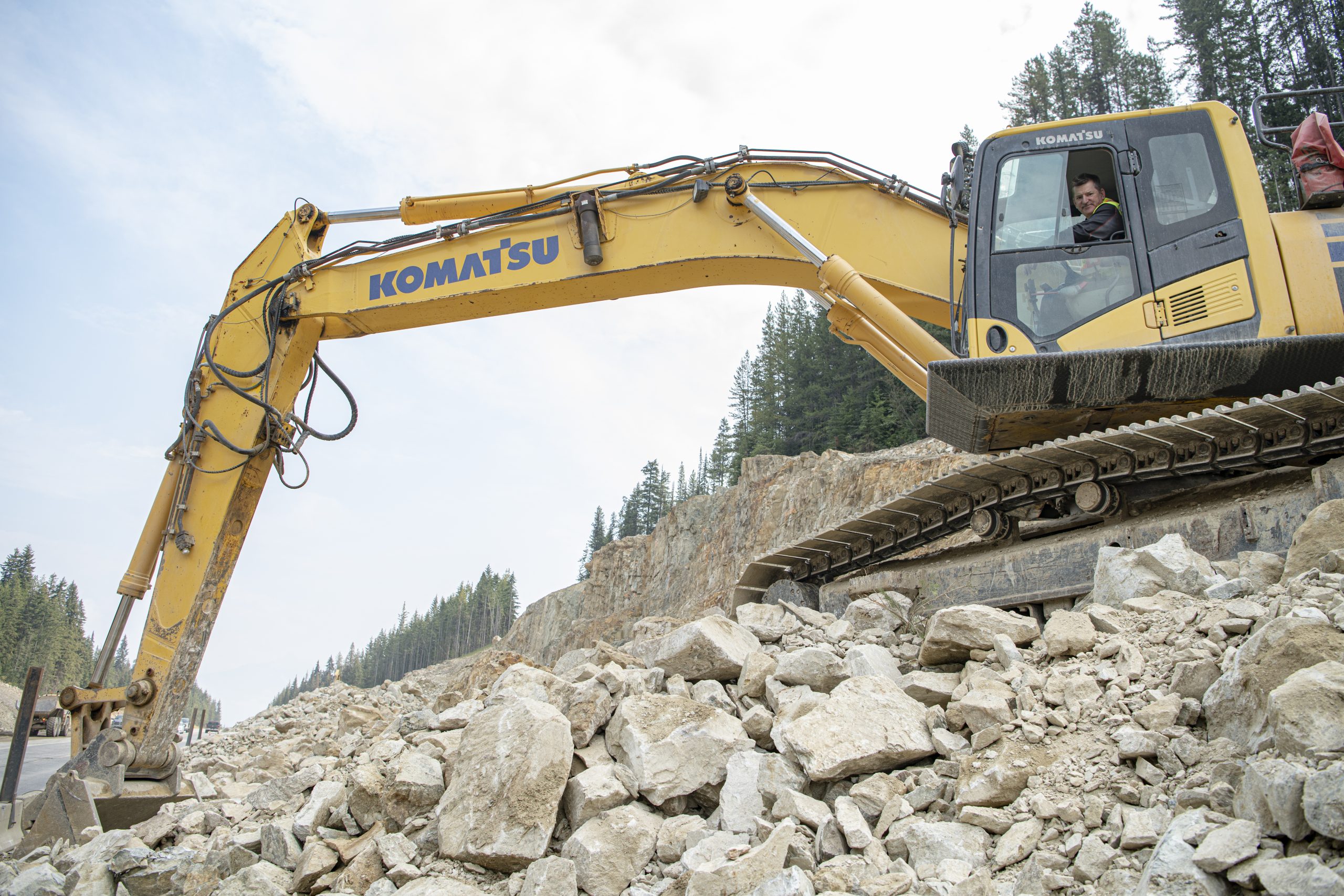 An image of an excavator and a BCIB employee